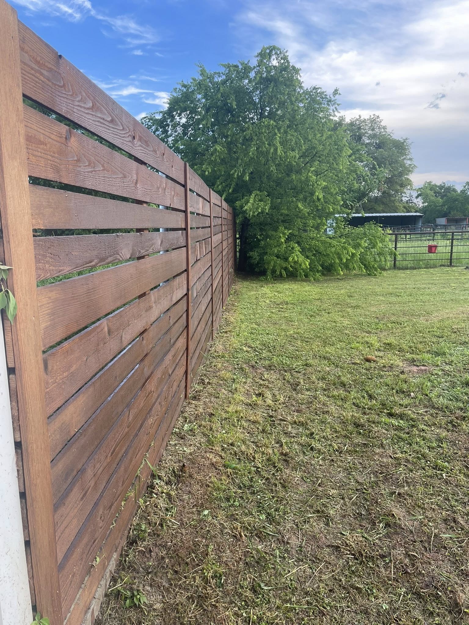 Wooden privacy fence installation in residential backyard for improved security and property value – Hood Lawn Care and Services