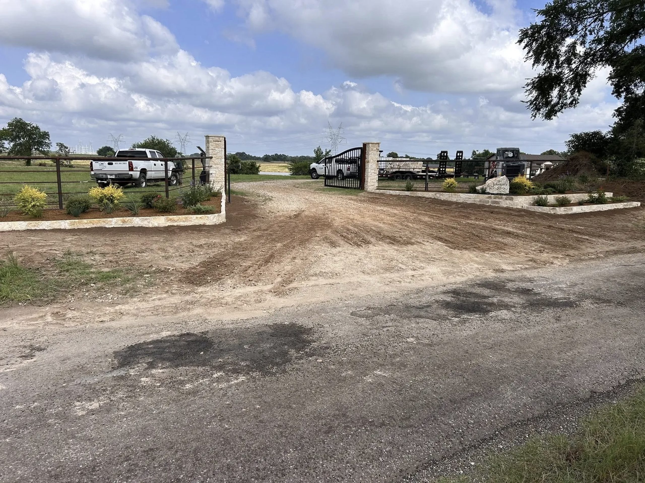 Property entrance with trucks and equipment after tree removal and land clearing – Hood Lawn Care and Services