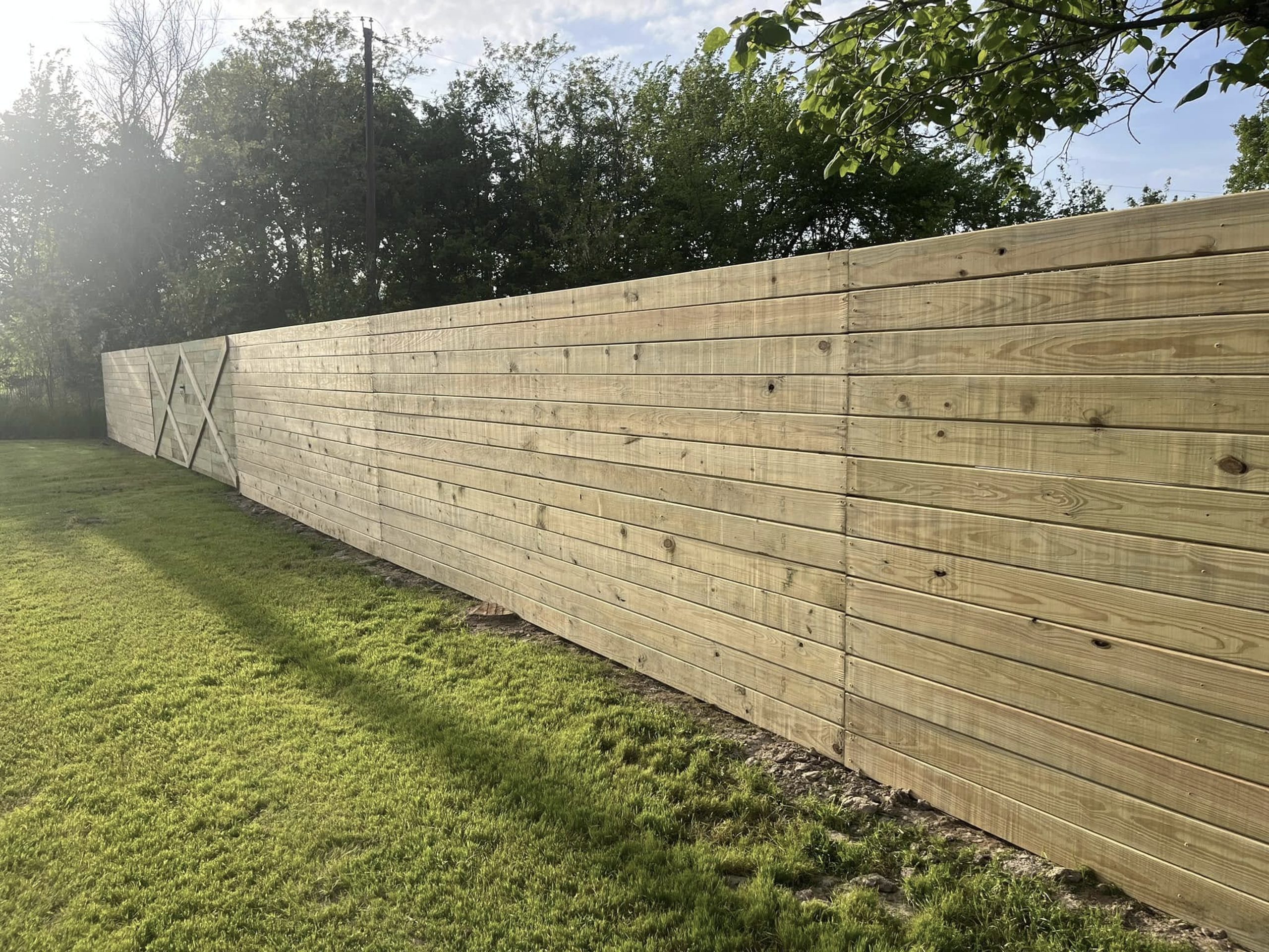 Wooden privacy fence installation in residential backyard for improved security and property value – Hood Lawn Care and Services