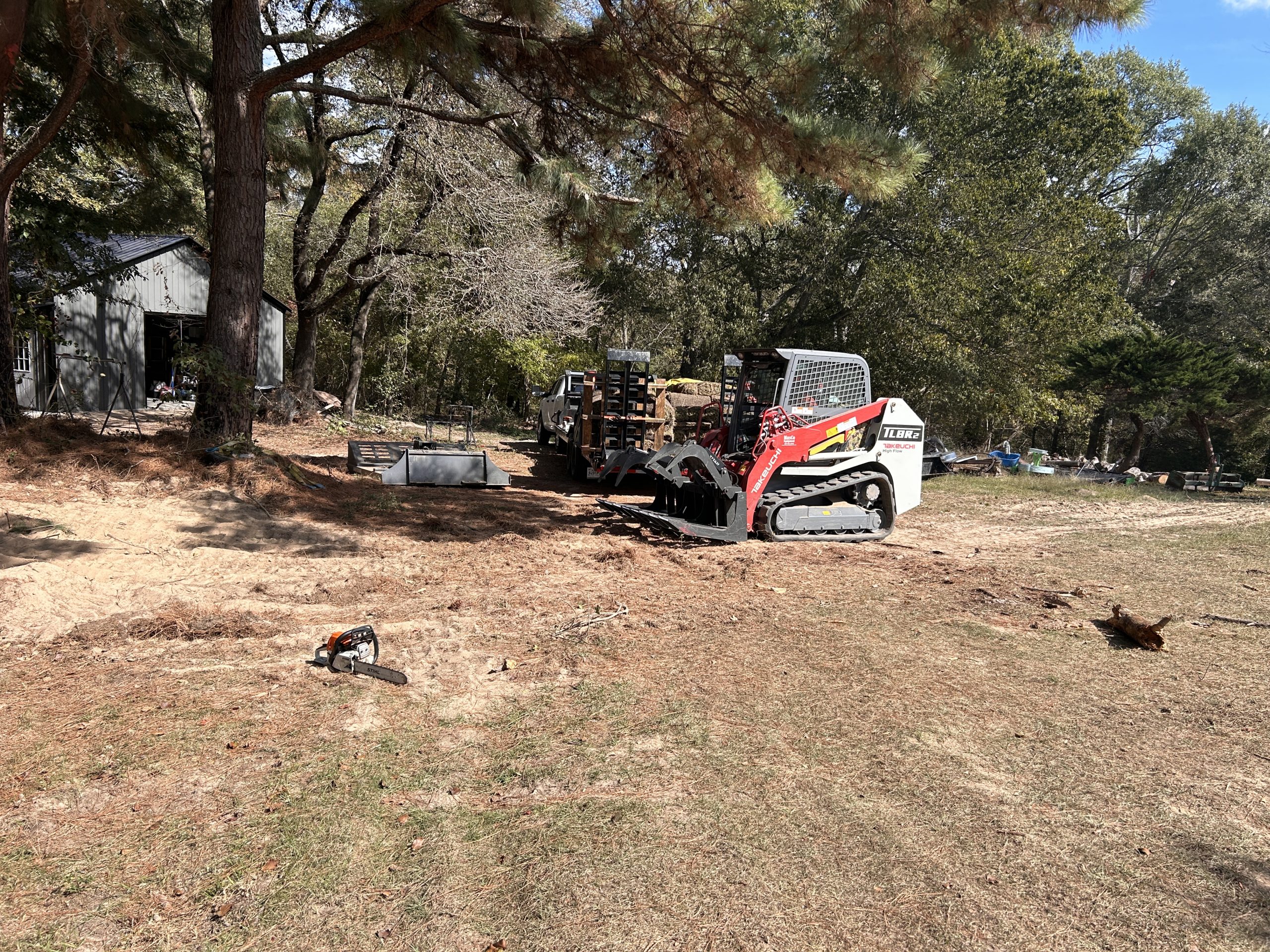 Land clearing with skid steer and chainsaw equipment for residential property maintenance – Hood Lawn Care and Services.
